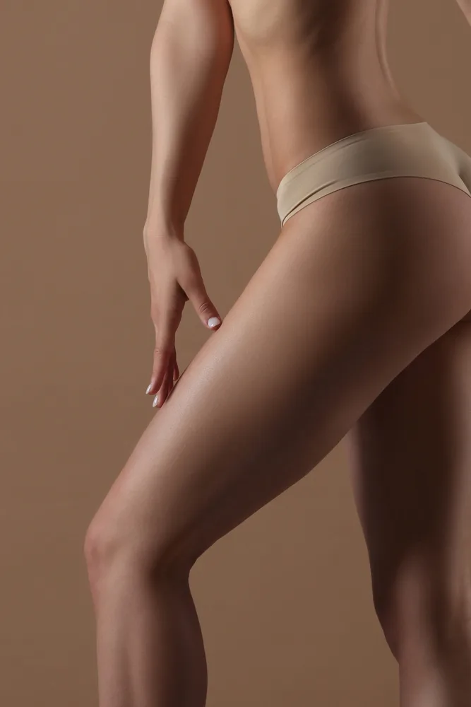 Woman touching her leg, demonstrating skin texture and body contour