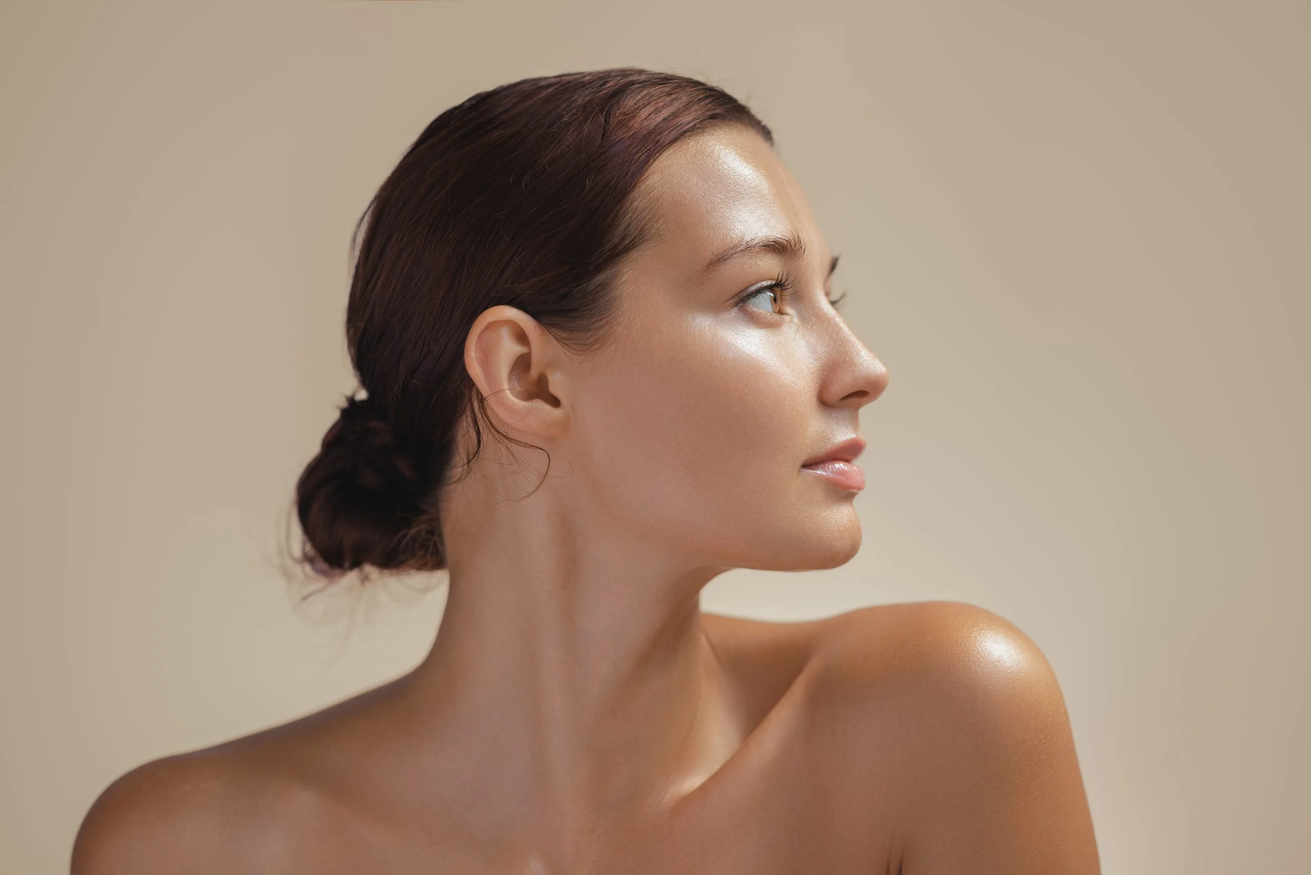 Woman in profile with pulled-back hair looking to the side