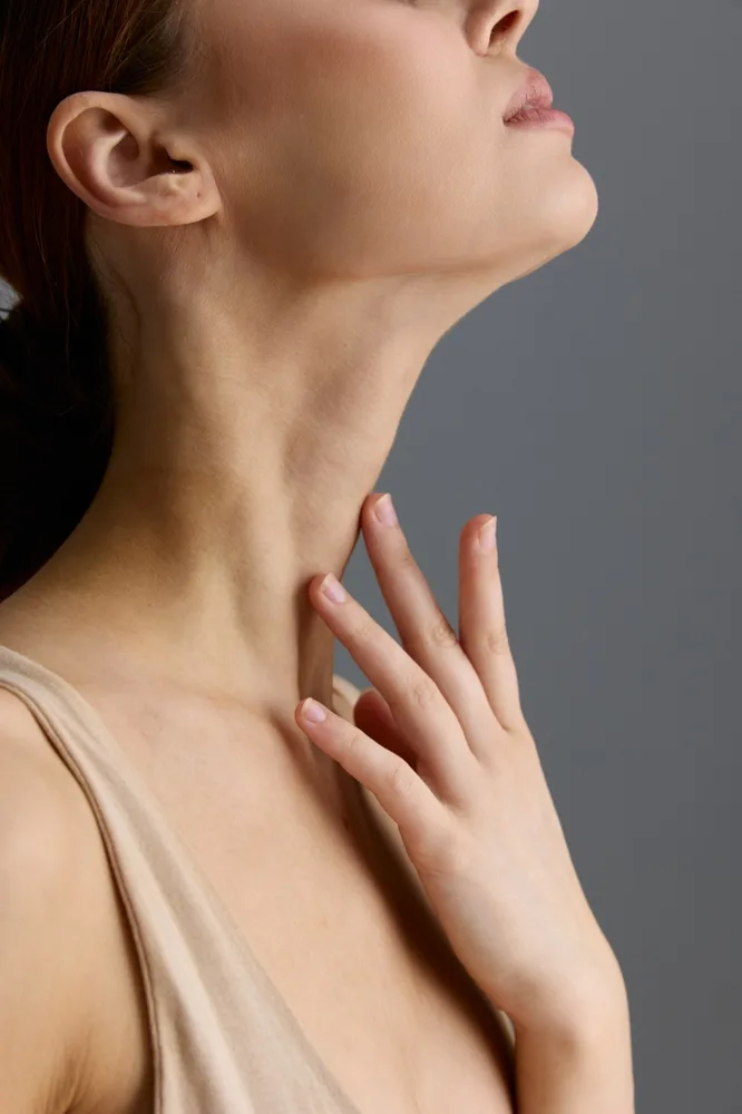 Woman in profile with hand on neck demonstrating skin texture