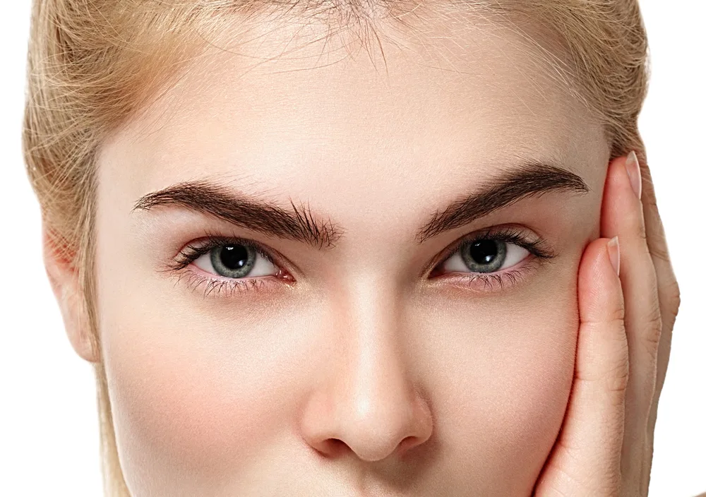 Woman touching her face with hand, skin close-up