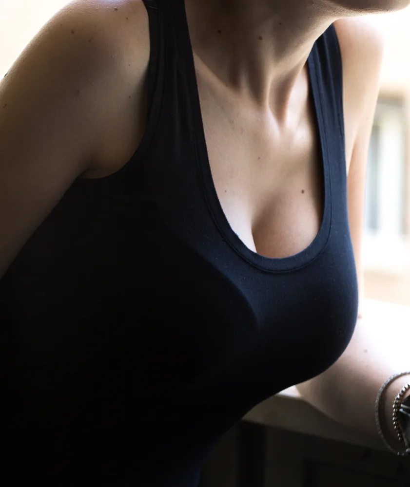 Close-up of woman's chest and shoulders wearing dark sleeveless top