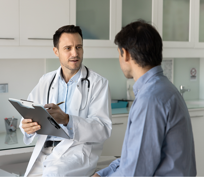 Doctor in white coat reviewing clipboard with male patient in medical office