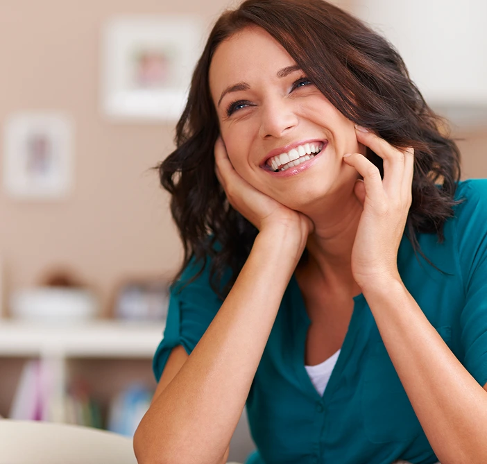Smiling woman in teal medical scrubs in clinical setting