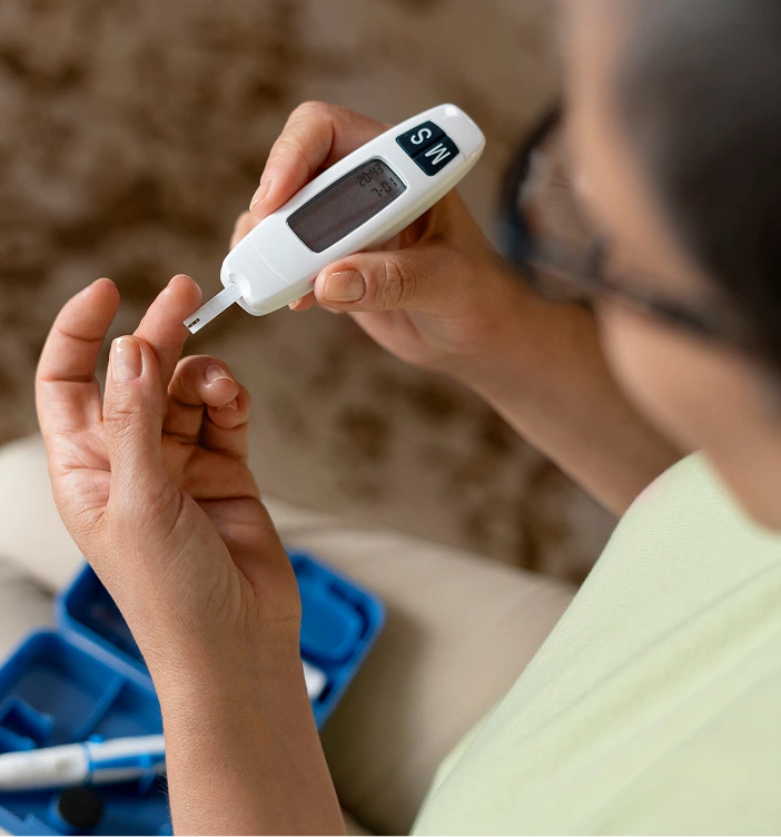 Person using portable glucose meter to check blood sugar level