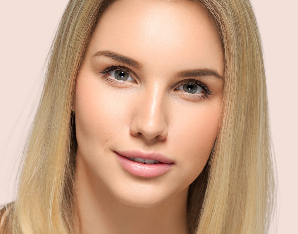 Woman with blonde hair and natural makeup looking at camera